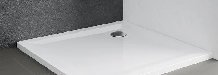 Weiße Duschwanne in einer Badezimmerecke.